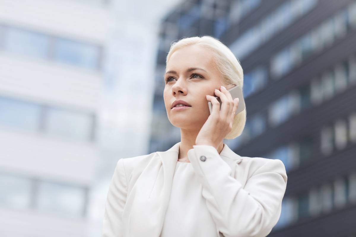 Blonde businesswoman in a white suit talking on her cellphone