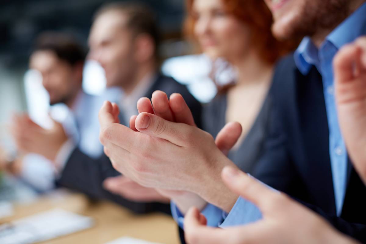 Business man and woman applauding in business attire 