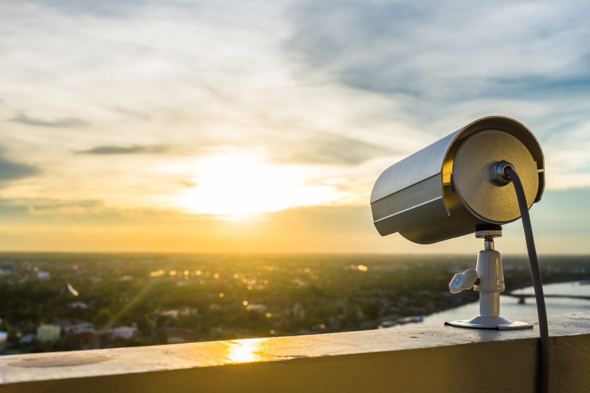 A surveillance camera facing a sunset and clouds