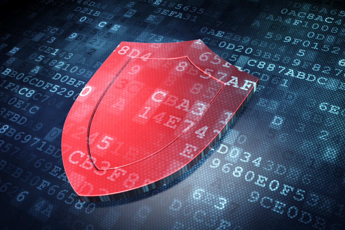 A 3D red transparent shield over lines of code to represent cybersecurity