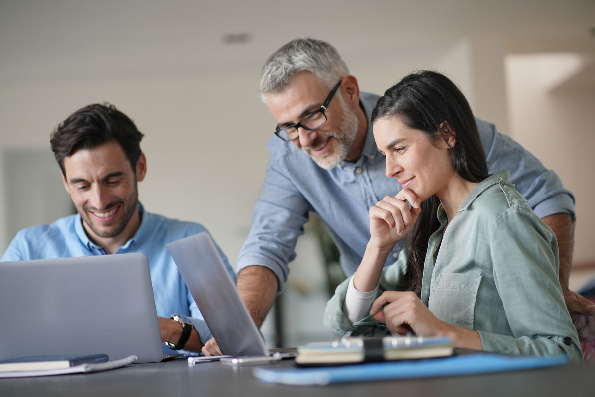 Three Colleagues Working Together with Computers