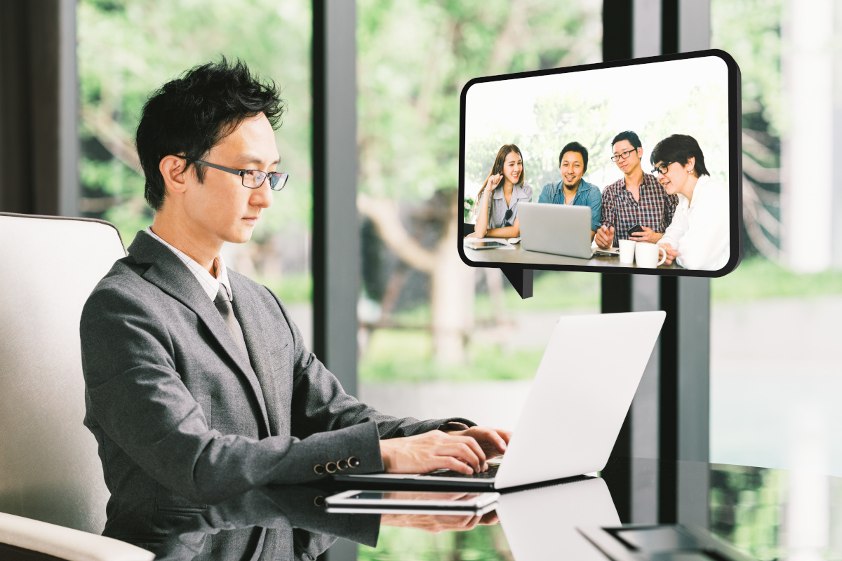 A man using unified communications to video conference with colleagues