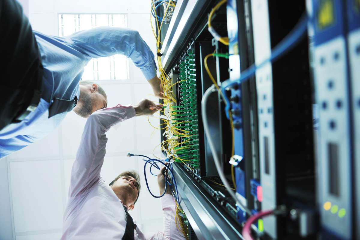 Low Angle View of Two IT Engineers in Network Server Room Managing Cables