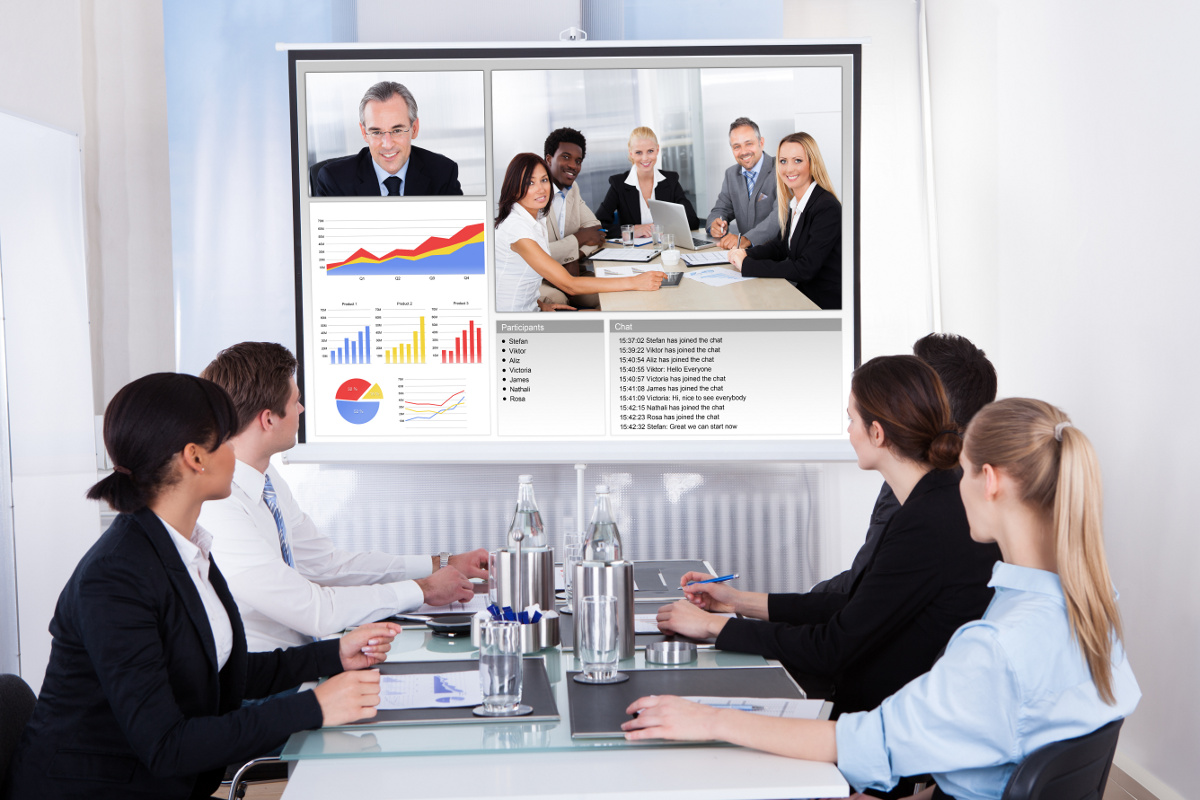 Business Team at Meeting Table Collaborating with Video Conferencing Unified Communication Solution